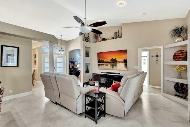 living area with built in shelves, baseboards, decorative columns, high vaulted ceiling, and a ceiling fan