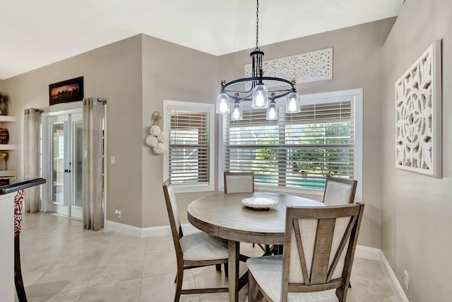 dining space featuring light tile patterned flooring, baseboards, and an inviting chandelier