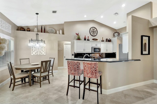 kitchen with visible vents, an inviting chandelier, lofted ceiling, stainless steel appliances, and white cabinets