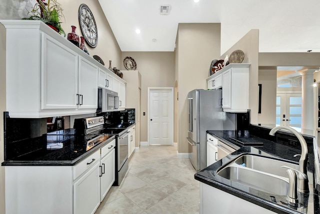 kitchen featuring a sink, stainless steel appliances, visible vents, and white cabinets