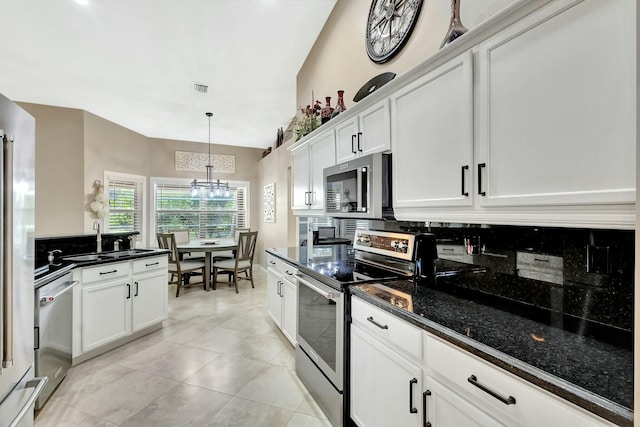 kitchen featuring a notable chandelier, a sink, backsplash, white cabinetry, and stainless steel appliances