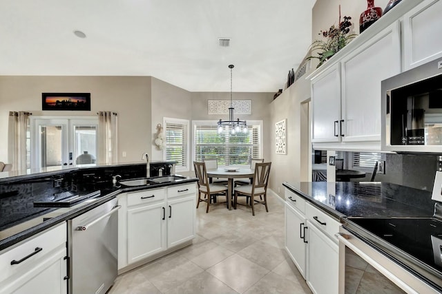 kitchen featuring visible vents, a chandelier, appliances with stainless steel finishes, white cabinetry, and a sink