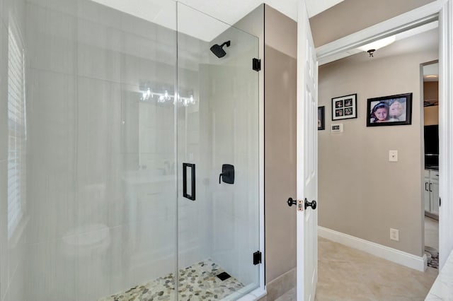 full bathroom featuring baseboards, a stall shower, a spacious closet, and tile patterned flooring