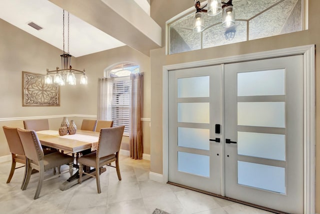 dining space with visible vents, baseboards, french doors, and vaulted ceiling