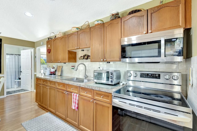 14618 66th St N, Loxahatchee, FL 33470 - kitchen featuring tasteful backsplash, a sink, light wood-type flooring, stainless steel appliances, and light countertops