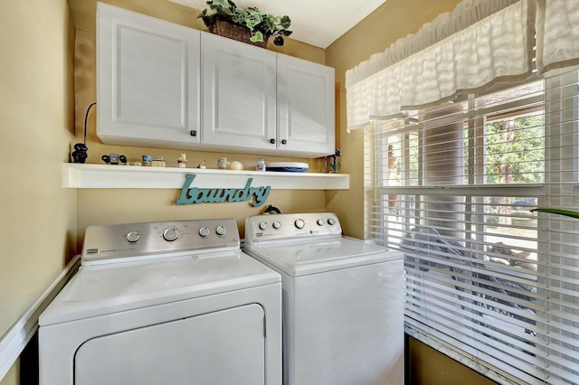 clothes washing area featuring cabinet space and washing machine and dryer