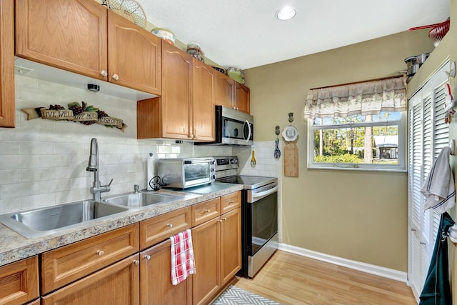 14618 66th St N, Loxahatchee, FL 33470 - kitchen with a sink, a toaster, baseboards, decorative backsplash, and appliances with stainless steel finishes