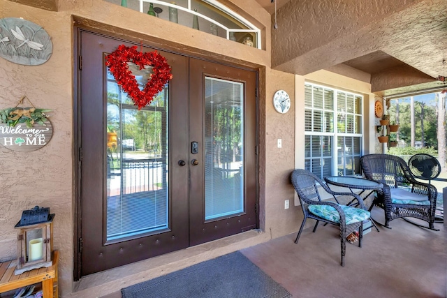 property entrance featuring french doors and stucco siding