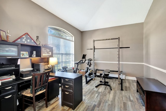 office with light wood finished floors and vaulted ceiling