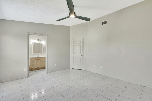 5489 NW Evanston Ave, Port Saint Lucie, FL 34983 - unfurnished bedroom with light tile patterned flooring, ceiling fan, ensuite bath, a textured ceiling, and baseboards
