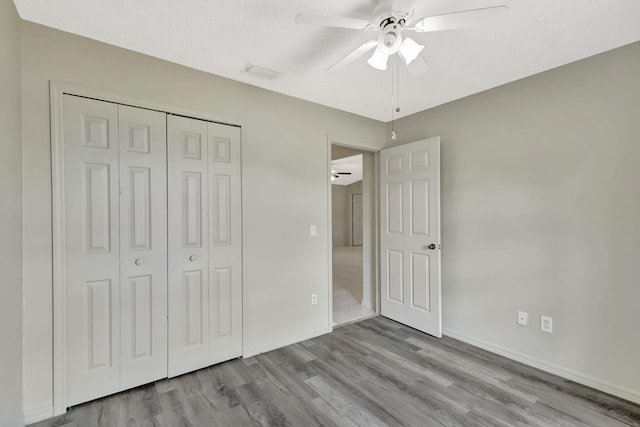 5489 NW Evanston Ave, Port Saint Lucie, FL 34983 - unfurnished bedroom featuring wood finished floors, a closet, baseboards, ceiling fan, and a textured ceiling