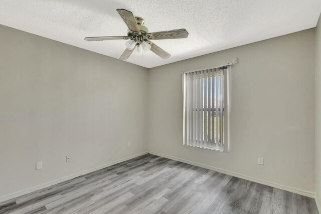 5489 NW Evanston Ave, Port Saint Lucie, FL 34983 - unfurnished room with wood finished floors, a ceiling fan, a textured ceiling, and baseboards
