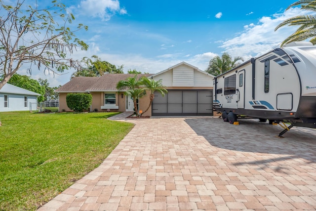 view of front facade with a front lawn, decorative driveway, a garage, and stucco siding