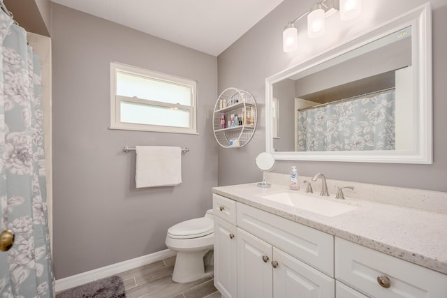 bathroom featuring vanity, toilet, baseboards, and wood finish floors