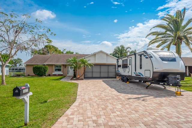 view of front of home featuring a garage, decorative driveway, and a front lawn