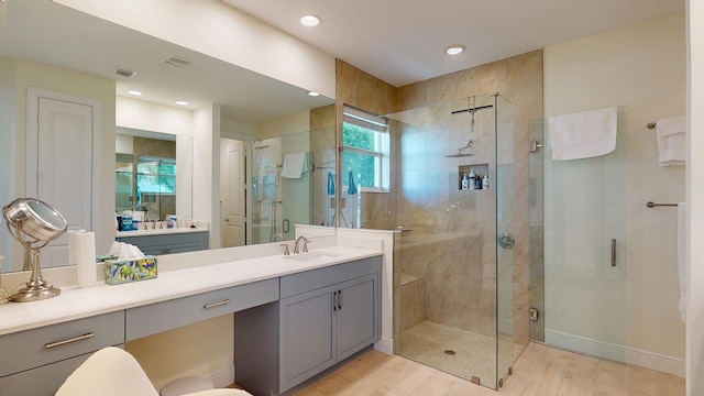 full bath featuring vanity, wood finished floors, baseboards, recessed lighting, and a shower stall