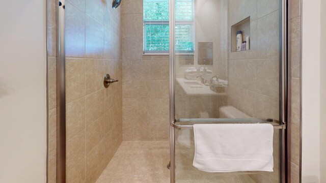 bathroom featuring a stall shower and a sink