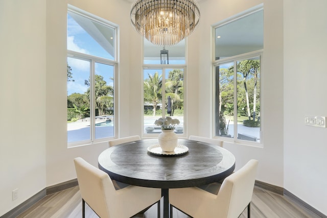 dining room with a healthy amount of sunlight, baseboards, an inviting chandelier, and wood finished floors