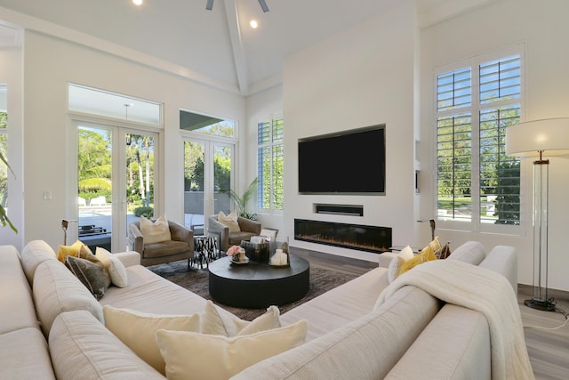 living area with high vaulted ceiling, a ceiling fan, wood finished floors, a glass covered fireplace, and recessed lighting