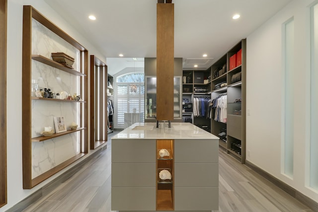 walk in closet with light wood-style floors