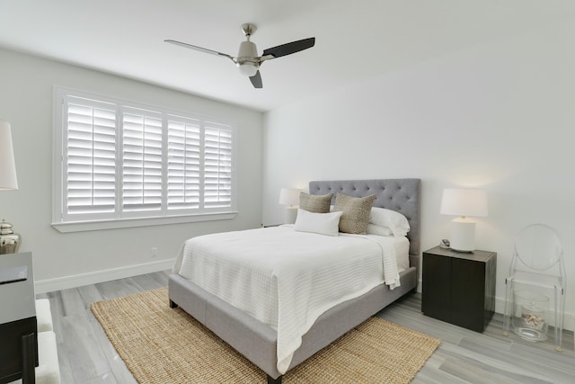 bedroom with ceiling fan, baseboards, and light wood-style flooring