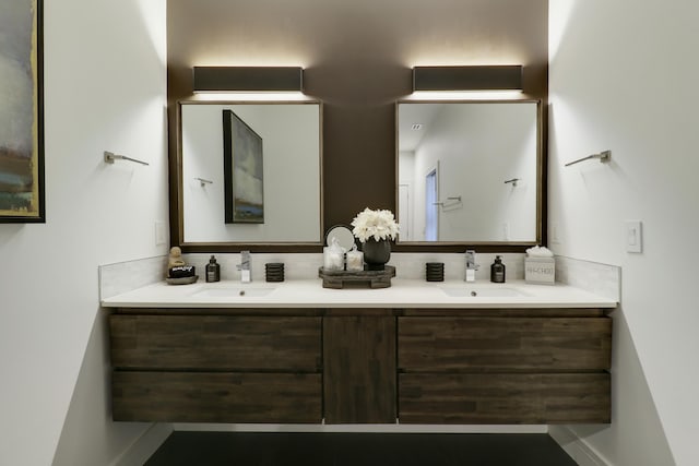 full bathroom with a sink, baseboards, and double vanity