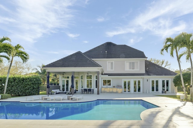 view of pool featuring a patio area, a fenced in pool, and french doors