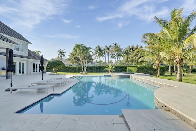 outdoor pool with a patio area and french doors