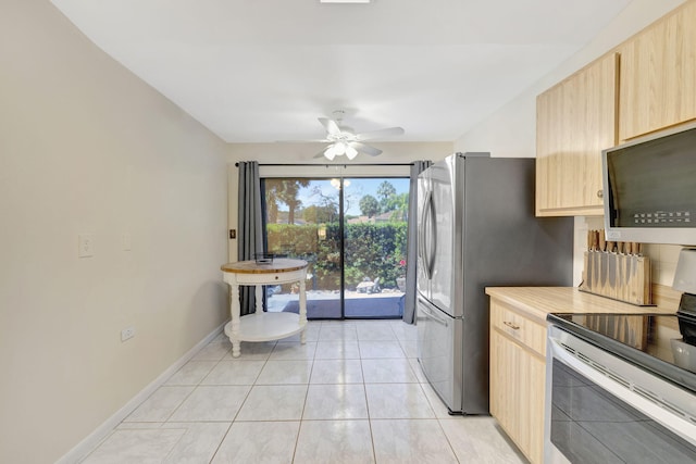 kitchen featuring light brown cabinets, baseboards, ceiling fan, light tile patterned floors, and stainless steel appliances