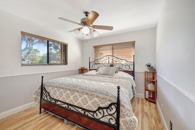 bedroom featuring light wood-style flooring, baseboards, and ceiling fan