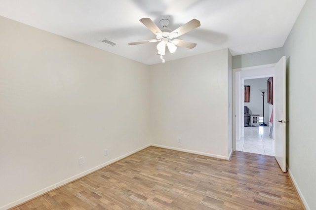 unfurnished room with baseboards, visible vents, light wood-type flooring, and ceiling fan