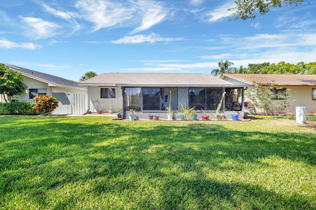 back of property featuring a lawn and a sunroom