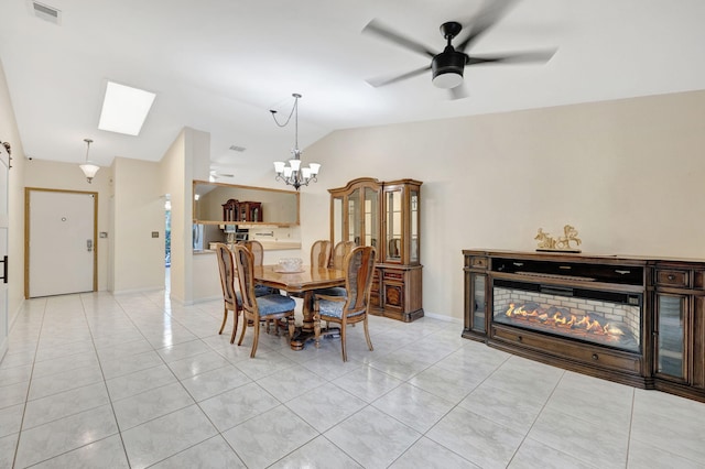 dining area featuring visible vents, baseboards, light tile patterned floors, ceiling fan with notable chandelier, and vaulted ceiling with skylight