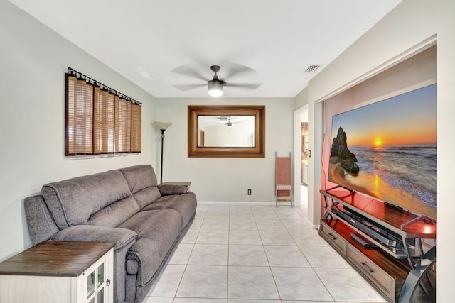 living room with light tile patterned floors, visible vents, baseboards, and ceiling fan