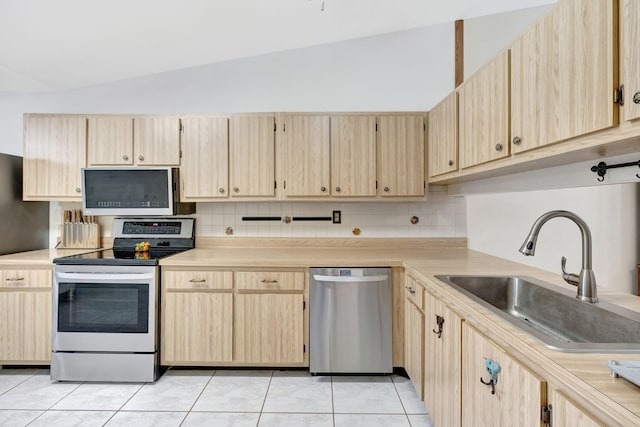 kitchen with light brown cabinetry, appliances with stainless steel finishes, and a sink