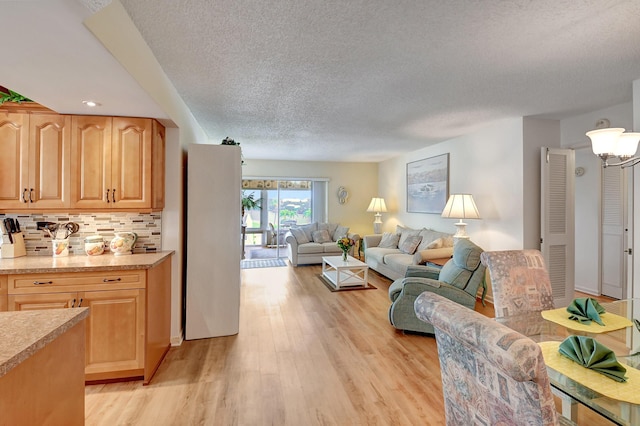 living area featuring light wood-style floors and a textured ceiling