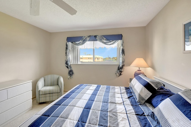 bedroom with a textured ceiling, ceiling fan, and carpet flooring