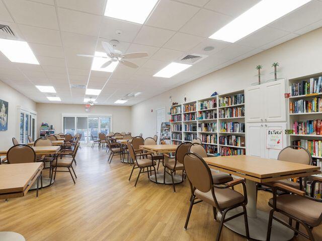 dining space with visible vents, a ceiling fan, light wood-style floors, and a drop ceiling