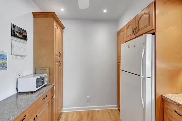 kitchen featuring white appliances, recessed lighting, light wood-style floors, and baseboards