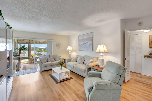 living area with a textured ceiling and light wood finished floors