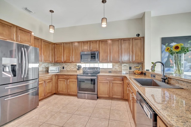 kitchen with backsplash, visible vents, appliances with stainless steel finishes, and a sink