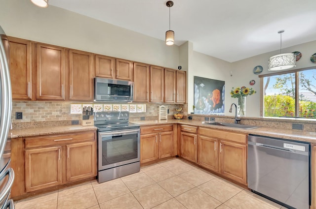 kitchen featuring decorative backsplash, decorative light fixtures, appliances with stainless steel finishes, and a sink