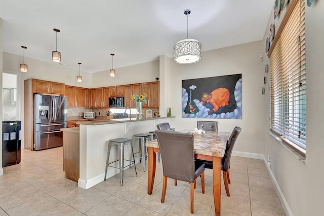 dining space with light tile patterned floors and baseboards