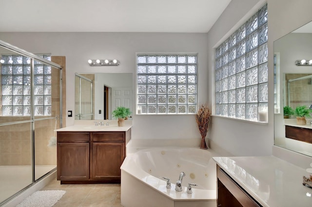 bathroom featuring tile patterned floors, vanity, a stall shower, and a whirlpool tub