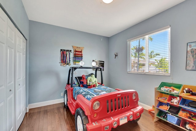 bedroom featuring hardwood / wood-style floors, baseboards, and a closet