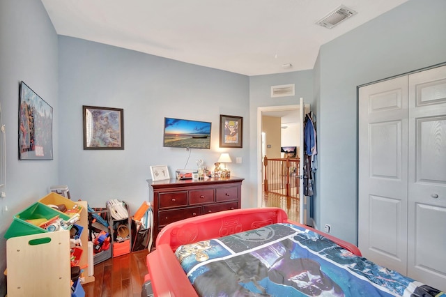 bedroom featuring visible vents, a closet, and wood finished floors