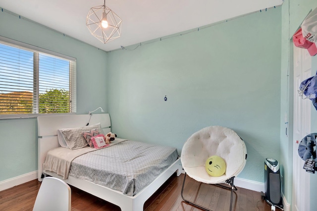 bedroom featuring wood finished floors and baseboards