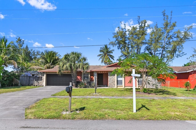 ranch-style home featuring aphalt driveway, an attached garage, a front yard, and fence