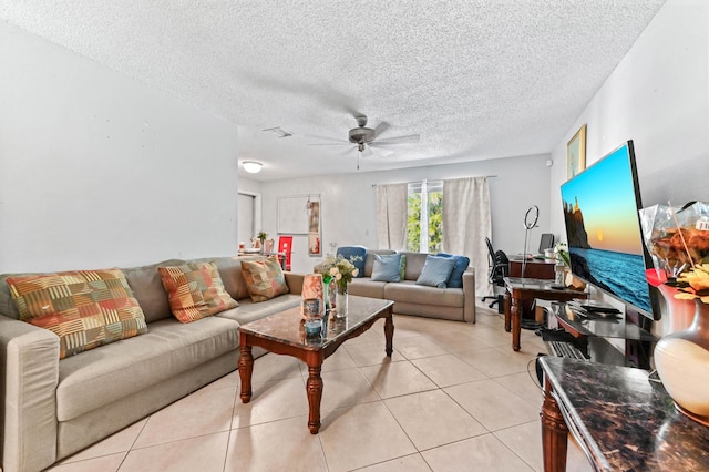 living area with light tile patterned floors, visible vents, a textured ceiling, and a ceiling fan