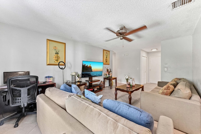 living area with light tile patterned flooring, visible vents, a textured ceiling, and a ceiling fan